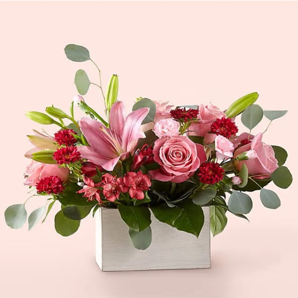 Pink roses and lilies arranged in a square box