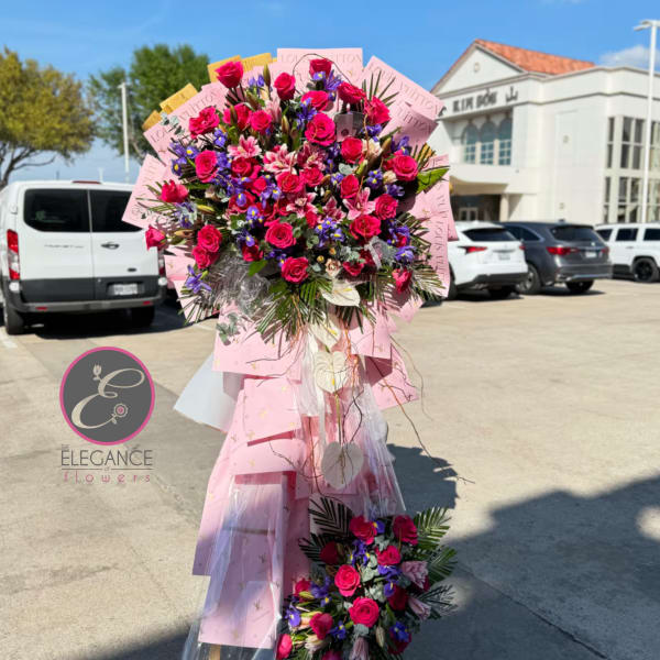 Large bouquet of pink roses and purple flowers wrapped in pink paper