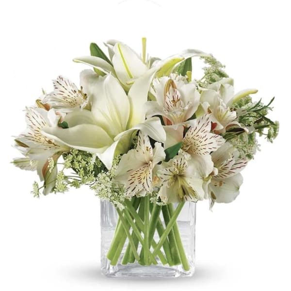 White lilies and speckled alstroemeria in a clear glass vase