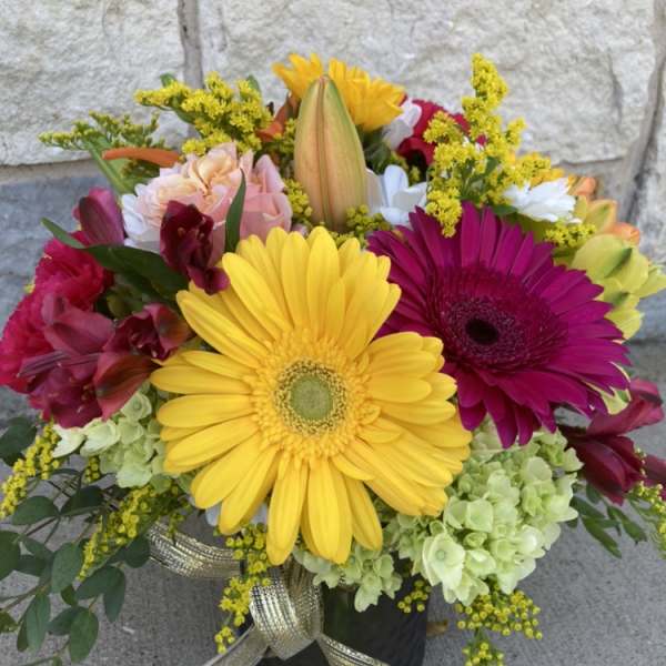 Colorful bouquet with yellow and magenta gerbera daisies in a black vase