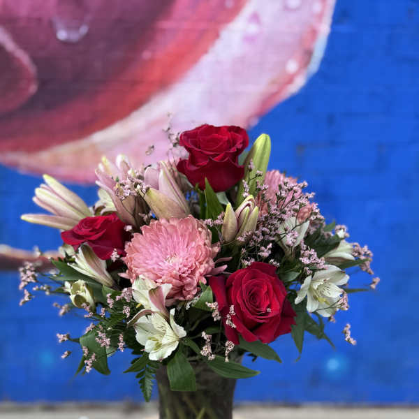 Bouquet of red roses and pink flowers in a glass vase