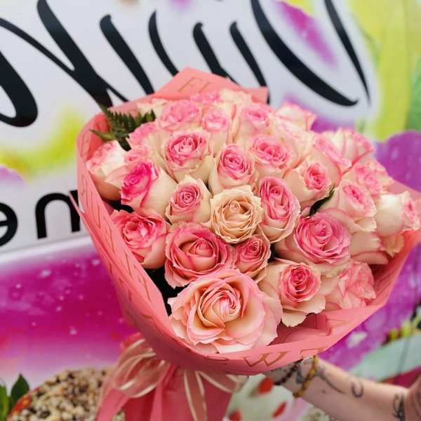 Bouquet of pink and peach roses wrapped in pink paper