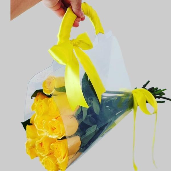 Bouquet of yellow roses wrapped in clear plastic with a yellow ribbon