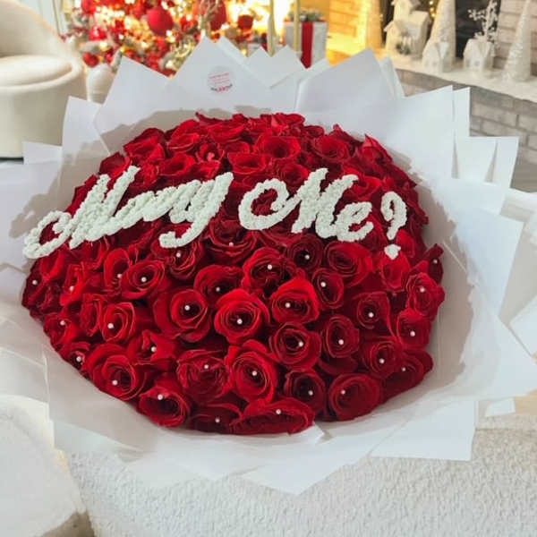 Large bouquet of red roses with white "Marry Me!" lettering