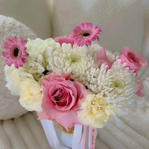 Pink and white bouquet with roses, chrysanthemums, and gerbera daisies in a white container