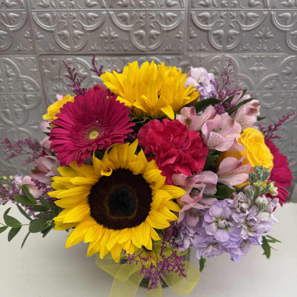 Mixed bouquet with sunflowers, pink gerberas, and pastel blooms