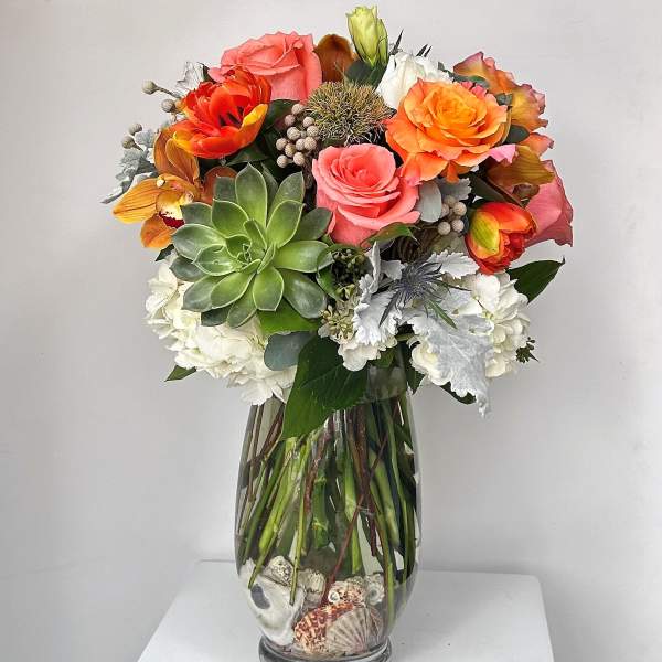 Mixed bouquet in a glass vase with succulents and roses
