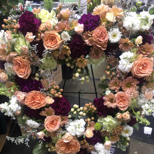 Heart-shaped floral wreath with peach roses and purple blooms