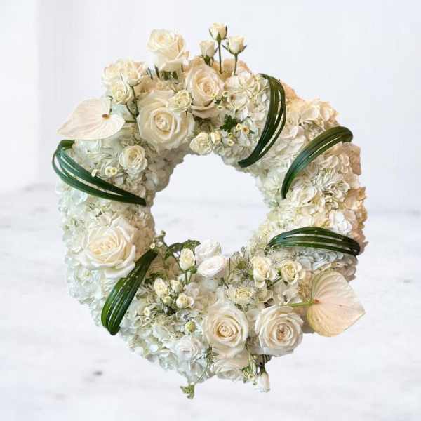White floral wreath with roses and hydrangeas on a white background