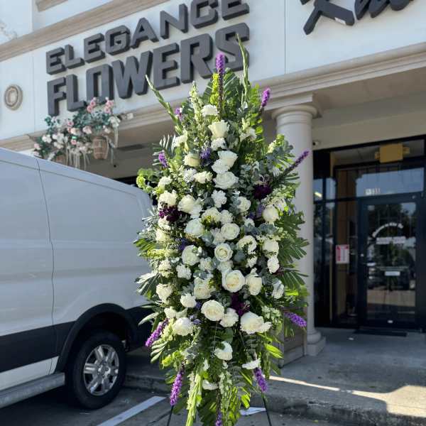 Tall white and purple floral standing spray on an easel