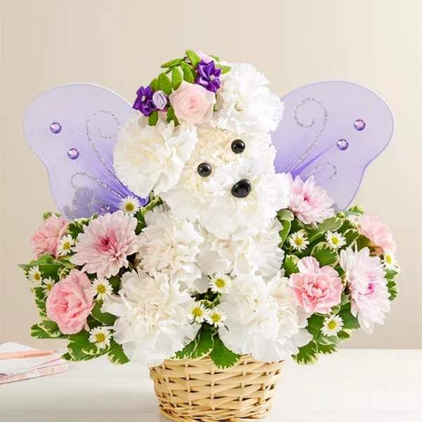 White and pink flower arrangement in a wicker basket with purple butterfly wings