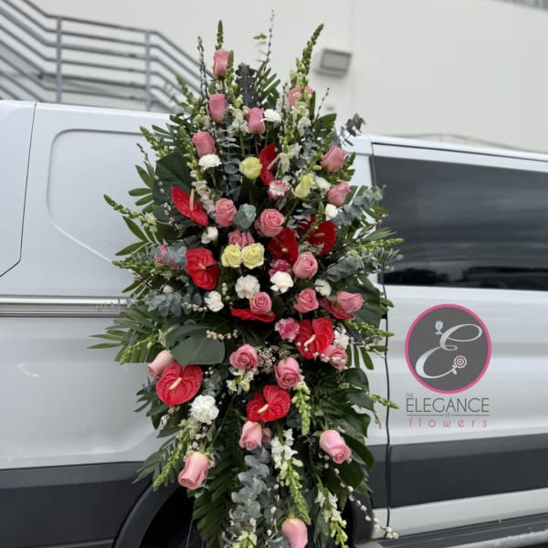 Tall standing floral spray with pink roses and red anthuriums