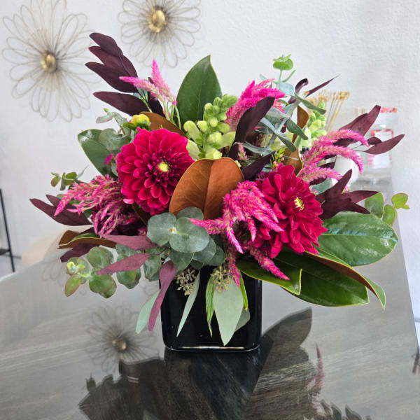 Pink and magenta flowers arranged in a black vase