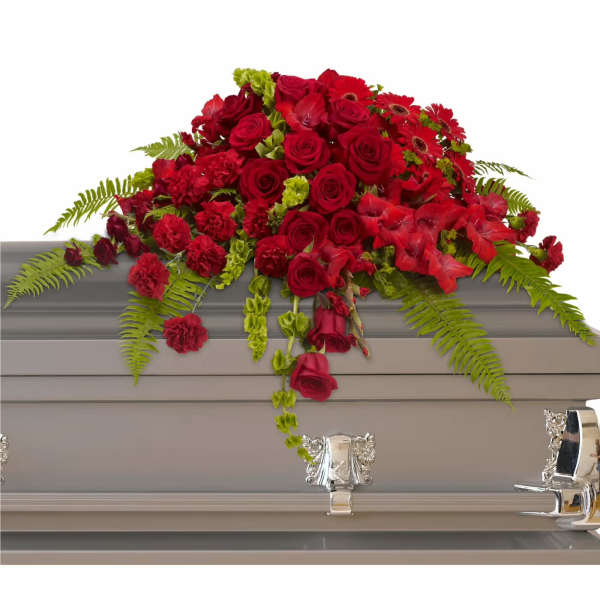 Red floral spray on a gray casket with fern accents