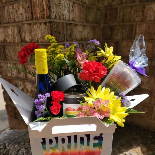 Rainbow flower gift box with a Pride label, bottle, candle, and cup
