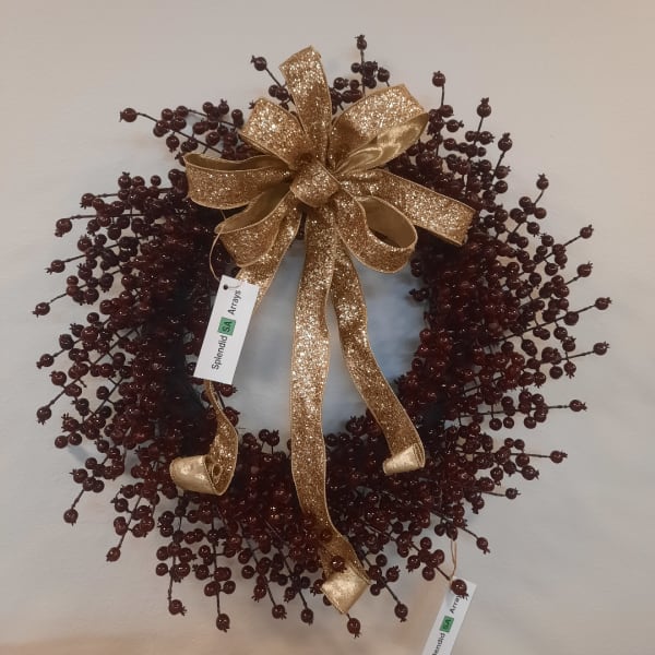Decorative berry wreath with a gold glitter bow