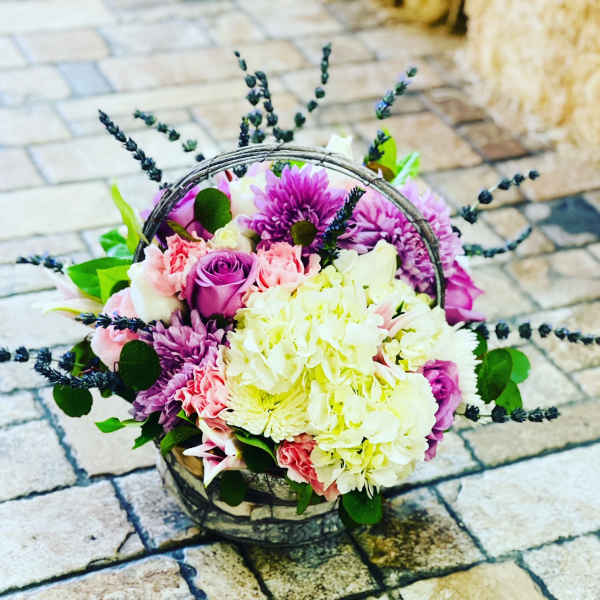 Basket of pink, purple, and white flowers with dark sprigs