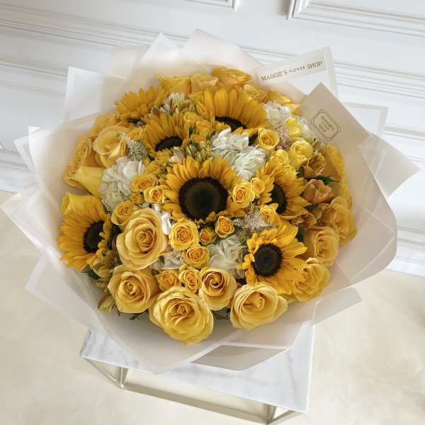 Yellow roses and sunflowers in a wrapped bouquet