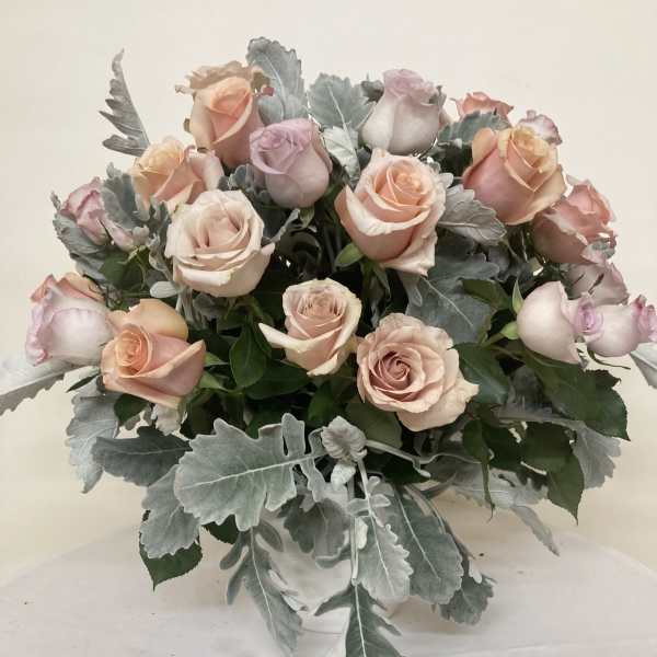 Bouquet of blush and peach roses in a clear vase