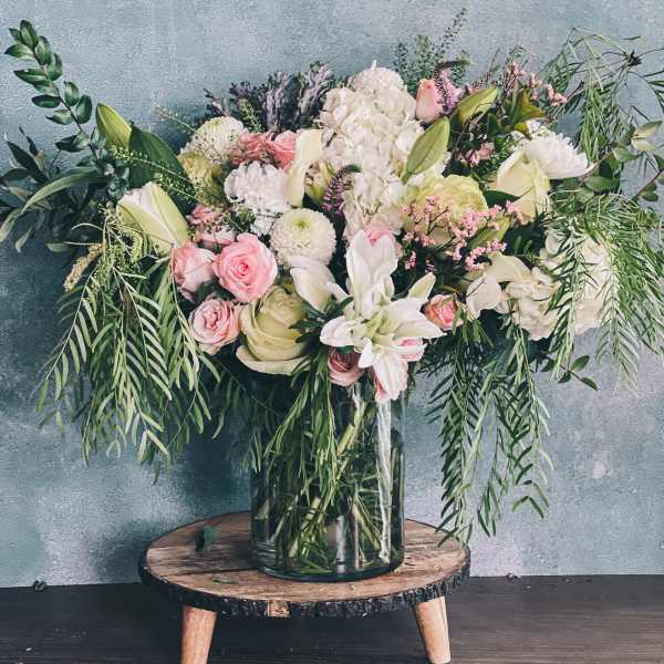 Large pastel bouquet in a glass vase with pink and white flowers
