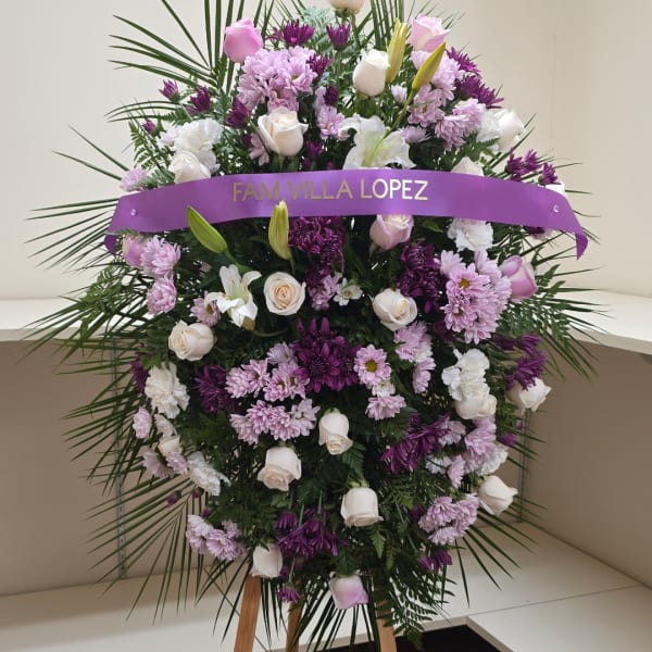 Standing floral spray with white and lavender flowers and a purple ribbon banner