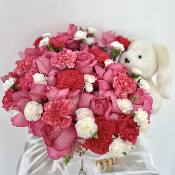 Basket flowers with teddy bear.