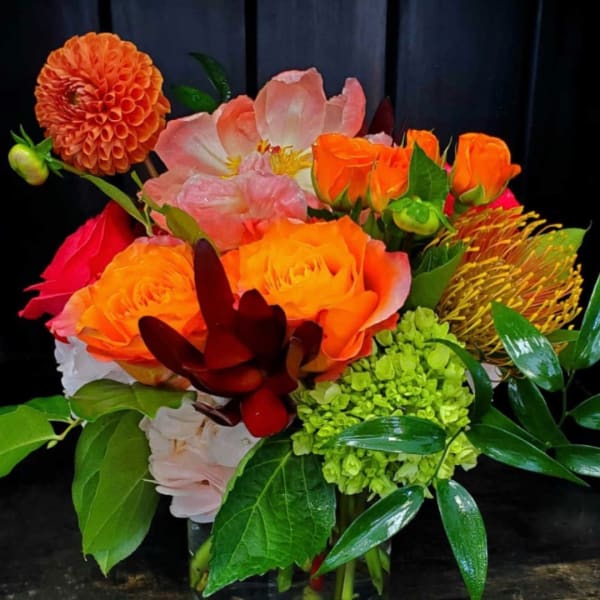 Bright mixed bouquet with orange and pink flowers in a vase