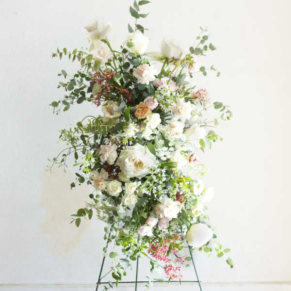 Tall floral spray with white and blush blooms on a metal stand