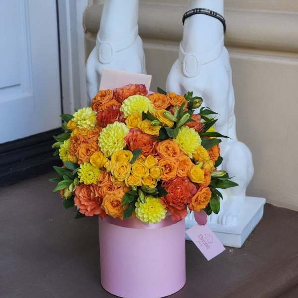 Orange and yellow rose bouquet in a pink cylindrical box
