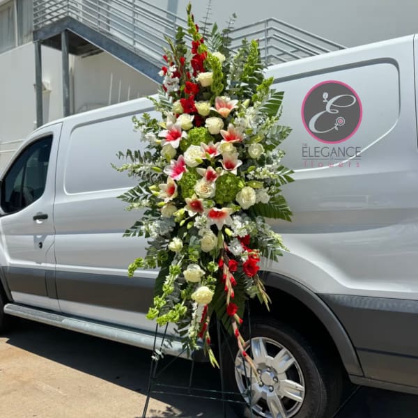 Tall floral standing spray with red, white, and green blooms