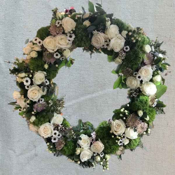 Heart-shaped floral wreath with white roses and green moss