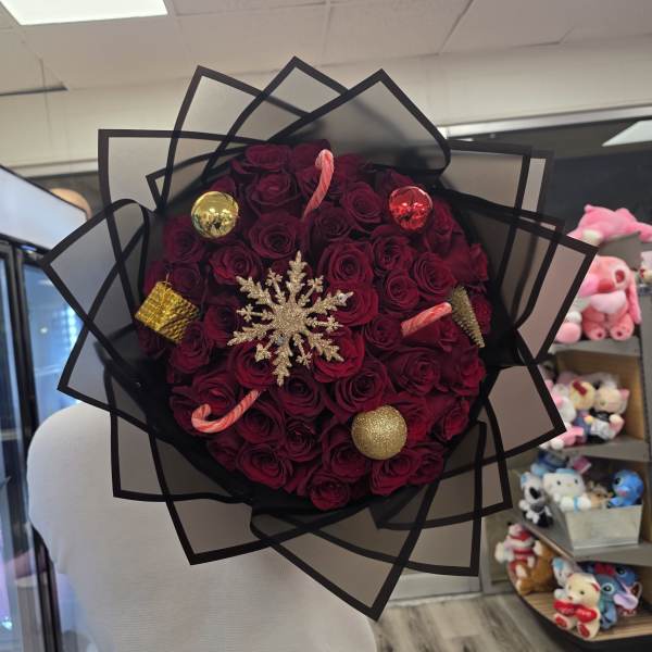 Round bouquet of dark red roses with holiday ornaments and a snowflake decoration