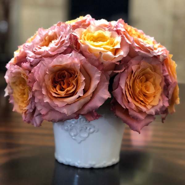 Bouquet of pink and peach roses in a white vase
