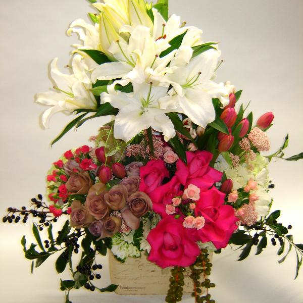 Mixed bouquet of white lilies and pink roses in a box