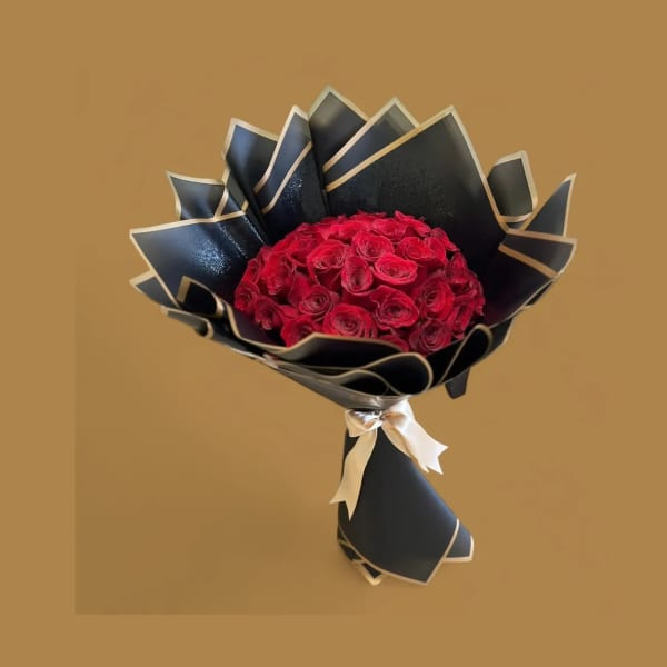 Bouquet of red roses wrapped in black paper with a ribbon