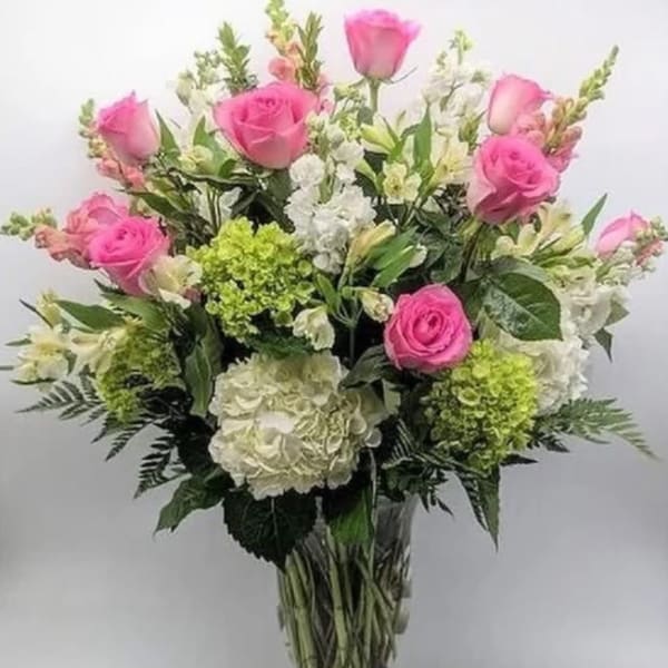 Pink roses and white hydrangeas in a clear glass vase