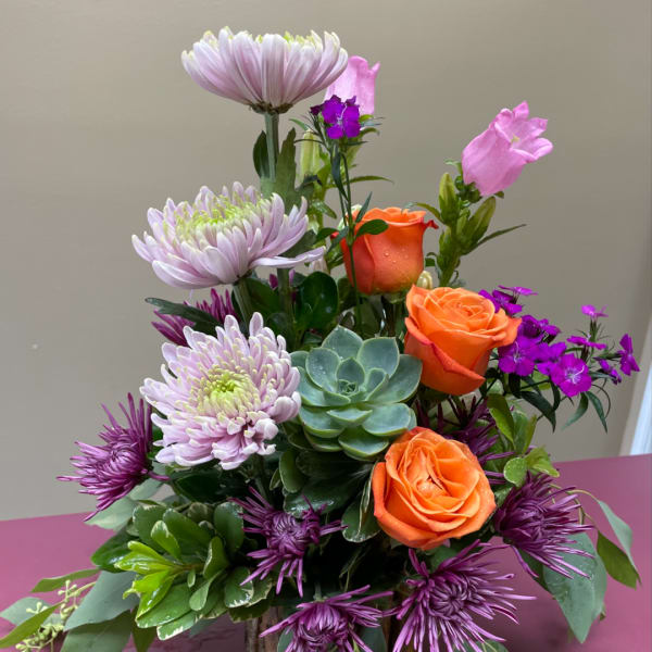Mixed bouquet with orange roses, lavender mums, and a succulent