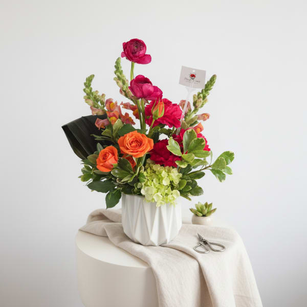 Bouquet of orange and pink flowers in a white vase