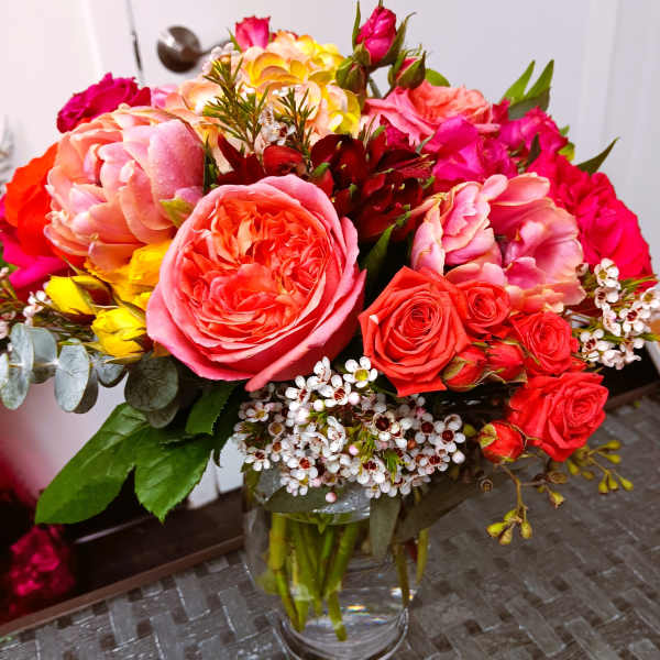 Mixed bouquet of pink and red roses in a clear glass vase