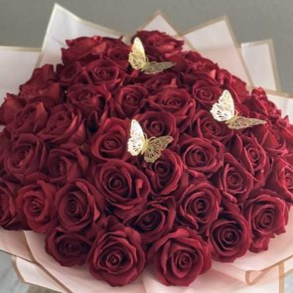 Bouquet of deep red roses with small butterfly decorations