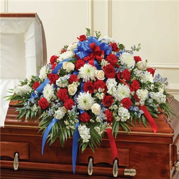 Casket spray of red and white flowers with blue and red ribbons