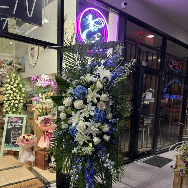 Tall blue and white floral standing arrangement on an easel
