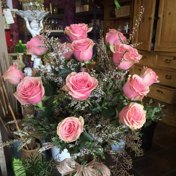 Pink roses in a clear glass vase with airy filler flowers