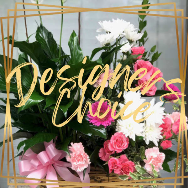 Mixed pink and white flowers in a basket with a pink ribbon