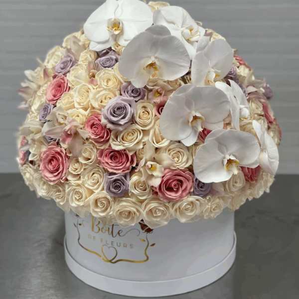 Round bouquet of white orchids and pastel roses in a white hat box