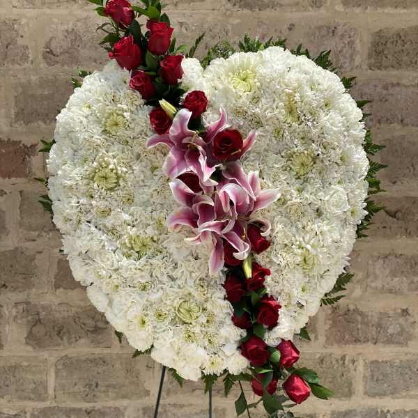 Heart-shaped white floral spray with red roses and pink lilies