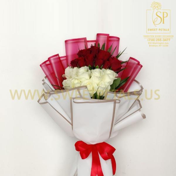 Bouquet of red and white roses wrapped in white paper with a red ribbon