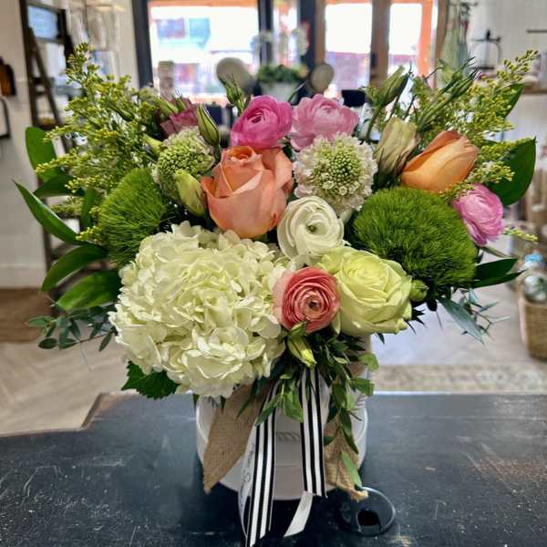 Mixed bouquet in a white hatbox with pink, peach, and white blooms