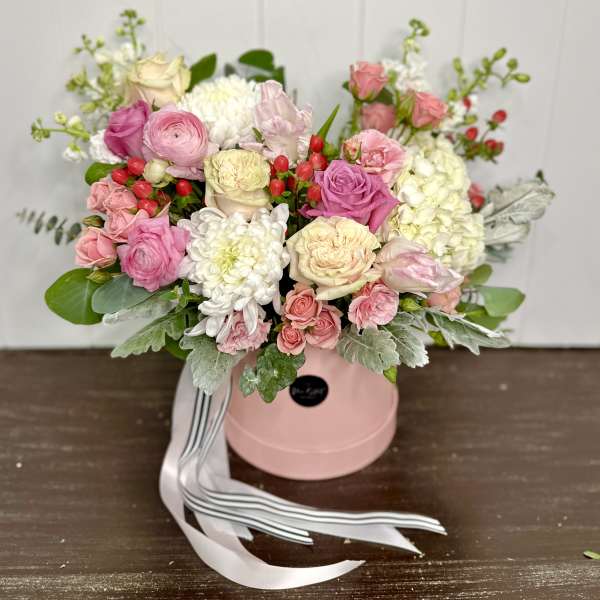 Pink and white rose bouquet in a pink hat box with ribbon.