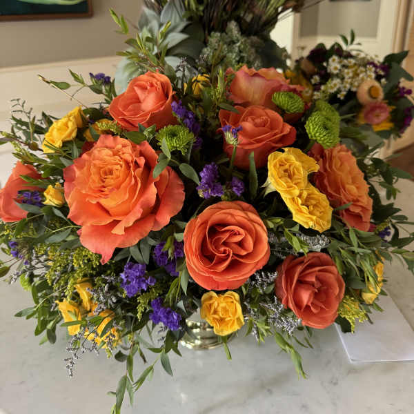 Bright mixed bouquet with orange and yellow roses in a vase